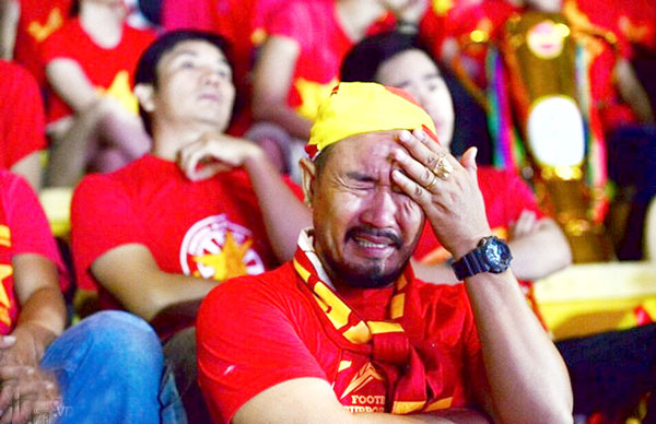 Một cổ động viên ôm mặt khi chứng kiến tuyển Việt Nam chia tay AFF Cup 2016 sau trận cầu kỳ lạ. Nguồn: Internet