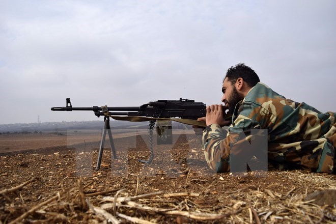 Lực lượng đối lập Syria giao tranh với quân đôi Chính phủ Syria tại làng Teir Maalah, tỉnh Homs ngày 5/12. (Nguồn: AFP/TTXVN)
