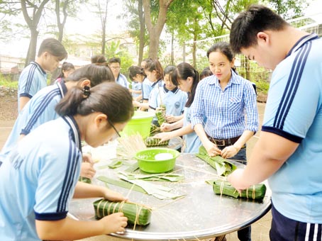 Học sinh và giáo viên lớp 11C2 Trường THPT Nam Hà (xã Hiệp Hòa, TP.Biên Hòa) cùng nhau gói bánh tét.