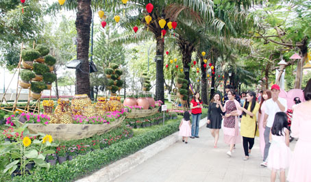 Du khách đến tham quan, chụp ảnh lưu niệm tại đường hoa Nguyễn Văn Trị với chủ đề “Biên Hòa - thành phố mùa xuân và khát vọng”.