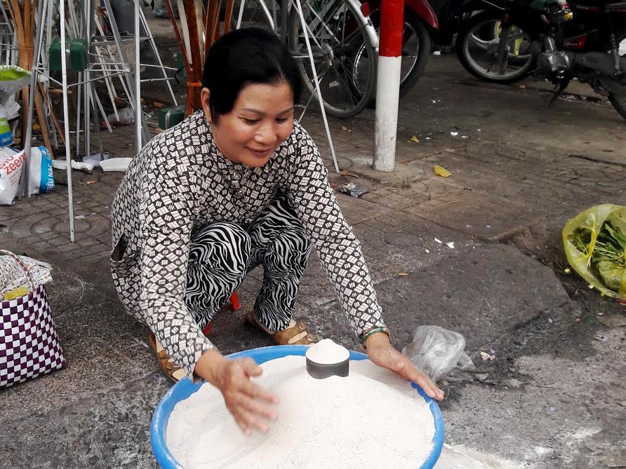Bà Trần Thị Ngọc bên chậu cát bỏ lư hương được bán ven chợ Biên Hòa