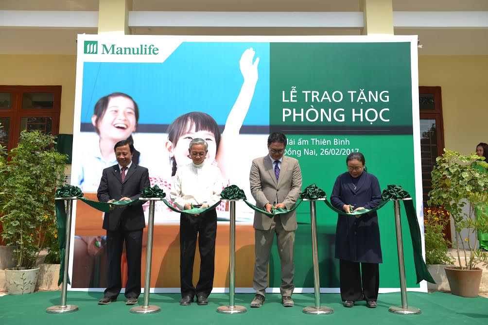 Đại điện Công ty TNHH Manulife Việt Nam và Cơ sở bảo trợ xã hội Mái ấm Thiên Bình thực hiện nghi thức cắt băng khánh thành phòng học
