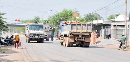 Xe ben chở vật liệu xây dựng chạy thành đoàn trên tỉnh lộ 767, đoạn qua huyện Vĩnh Cửu.