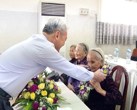 Bí thư Tỉnh ủy Nguyễn Phú Cường trao tặng hoa cho bà mẹ Việt Nam anh hùng.