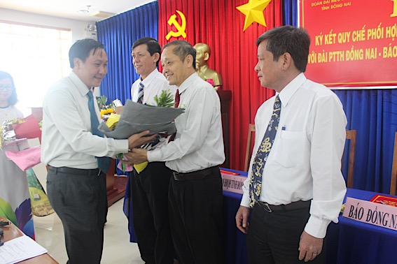 Phó trưởng đoàn chuyên trách Đoàn Đại biểu Quốc hội tỉnh tặng hoa cho Tổng biên tập Báo Đồng Nai Trần Huy Thanh..