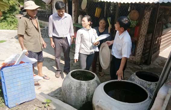 Cán bộ Trung tâm y tế dự phòng tỉnh Đồng Nai hướng dẫn người dân cách diệt lăng quăng.