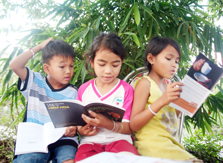 Trẻ em người dân tộc Cơho ở khu Lá Ủ (ấp Phú Kiên, xã Phú Bình, huyện Tân Phú) say sưa đọc sách. Ảnh: V.TRUYÊN