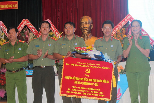 Đại tá Trần Thị Ngọc Thuận (bìa phải), Phó giám đốc Công an tỉnh tặng bức trướng của Ban chấp hành Đảng bộ Công an tỉnh tại đại hội