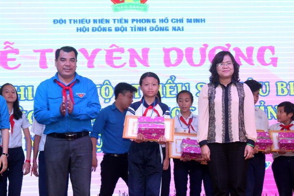 Phó chủ tịch UBND tỉnh Nguyễn Hòa Hiệp (phải) và Bí thư Tỉnh đoàn Nguyễn Cao Cường trao giấy khen và quà cho các em