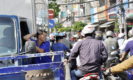 Tài xế xe tải tắt máy, xuống xe đứng chờ khi xảy ra kẹt xe nghiêm trọng ở vòng xoay Tân Phong.