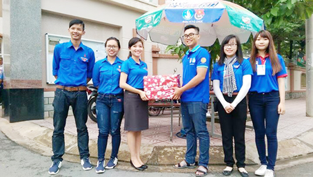 Phó bí thư Tỉnh đoàn, Chủ tịch Hội Sinh viên tỉnh Hồ Hồng Nguyên (thứ ba từ trái sang) tặng quà cho các sinh viên tình nguyện Tiếp sức mùa thi tại Hội đồng thi Trường TH-THCS-THPT song ngữ Lạc Hồng. Ảnh: P.Ảnh