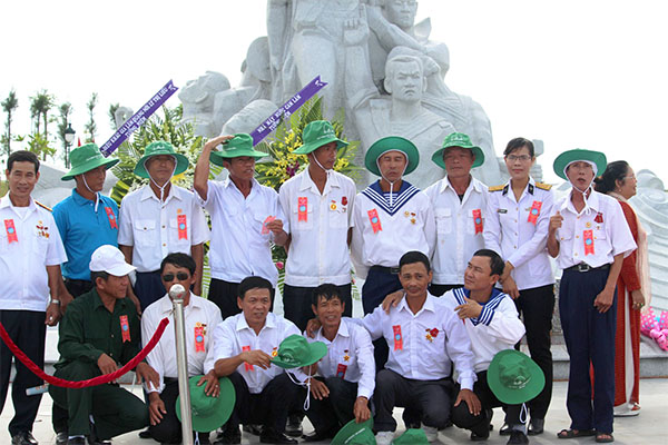 Các cựu chiến binh Gạc Ma chụp ảnh lưu niệm trước tượng đài, ảnh Mai Thắng