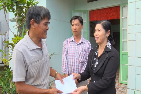 Bà Hà Thị Thanh- Chủ tịch UBMTTQ Huyện trao tiền hỗ trợ cho các gia đình bị tốc mái tại xã Xuân Mỹ