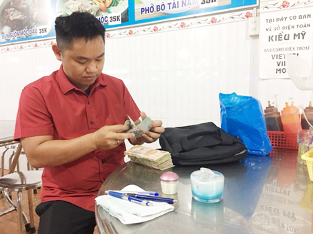 Ông Nguyễn Văn Hoàng kiểm đếm số tiền của khách bỏ quên tại nhà hàng.