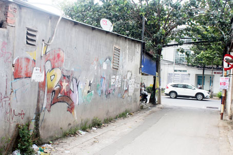 Mảng tường loang lổ những hình vẽ vô nghĩa, tờ rơi quảng cáo tại đầu hẻm 1377, đường Nguyễn Ái Quốc (đối diện Bệnh viện tâm thần trung ương 2).