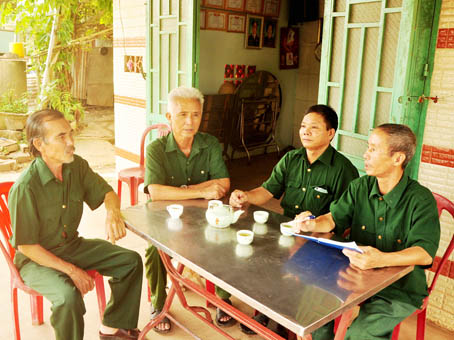 Ông Nguyễn Như Toàn, Chủ tịch Hội Cựu chiến binh xã Vĩnh Tân (phải), nghe các hội viên trình bày tình hình ở khu dân cư.