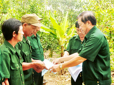 Đại tá Dương Hòa Hiệp (phải), Chủ tịch Hội Cựu chiến binh tỉnh, trao vốn tượng trưng cho các hộ hội viên nghèo ở huyện Tân Phú.