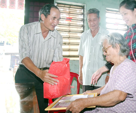 Chủ tịch Hội Người cao tuổi thị trấn Tân Phú (huyện Tân Phú) Phạm Văn Bằng (bìa trái) thăm và tặng quà mừng thọ cho một hội viên.
