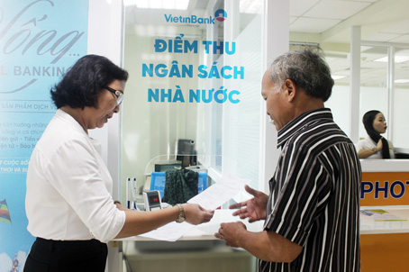 Nhân viên Ngân hàng thương mại cổ phần công thương Việt Nam chi nhánh Đồng Nai hướng dẫn người dân nộp tiền thuế tại Trung tâm hành chính công tỉnh Đồng Nai.