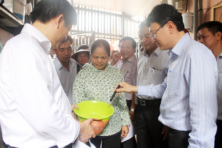Thứ trưởng Bộ Y tế Nguyễn Thanh Long (bìa trái) phát hiện một vật chứa nước có lăng quăng tại một hộ dân ở KP.5, phường Long Bình (TP.Biên Hòa). Ảnh: N.THƯ
