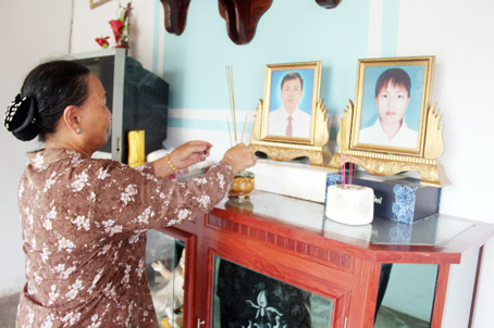 Bà Trần Thị Thục bên bàn thờ vợ chồng người con trai mất vì tai nạn giao thông.