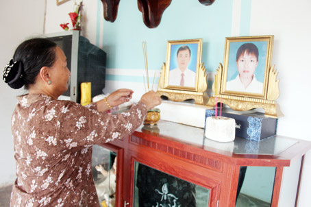 Bà Trần Thị Thục bên bàn thờ vợ chồng người con trai mất vì tai nạn giao thông.