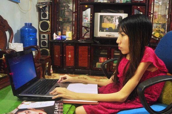 Chị Phạm Tuyết Trinh với công việc hàng ngày trên máy vi tính tại nhà.