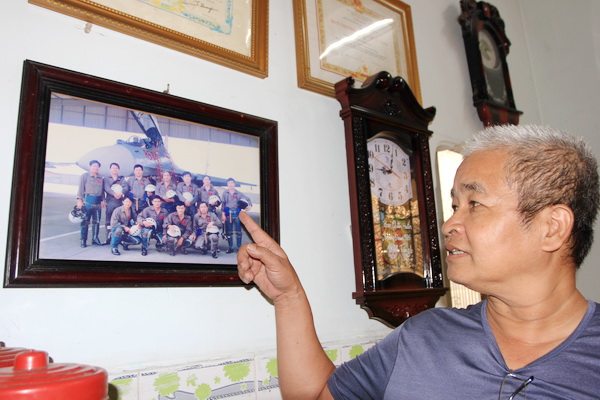 Ông Nguyễn Ngọc Ngân bên tấm ảnh chụp chung với giáo viên và đồng đội khi học phi công ở Liên Xô từ năm 1980-1984