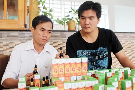 Tinh dầu gấc của anh Nguyễn Tiến Chương (trái) được chào bán qua mạng và các đại lý trong nước.