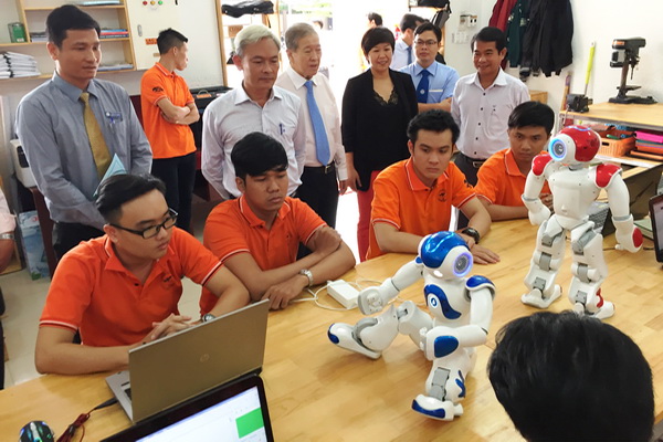 Bí thư Tỉnh ủy Nguyễn Phú Cường (hàng đứng, thứ hai từ trái qua) tham quan giờ thực hành lập trình ngôn ngữ cho robot giao tiếp với con người tại Trường đại học Lạc Hồng. Ảnh: C.Nghĩa