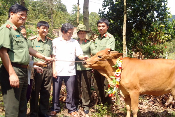 Chủ tịch Ủy ban  MTTQ tỉnh Huỳnh Văn  Tới(thứ 3 từ phải qua) cùng lãnh đạo Công  an tỉnh đi trao tặng  bò cho người nghèo ở  huyện Định Quán. Ảnh: P. HằNG