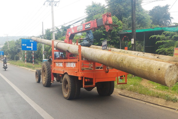 Xe máy cày chở trụ điện trên quốc lộ 20, đoạn qua xã Quang Trung, huyện Thống Nhất.