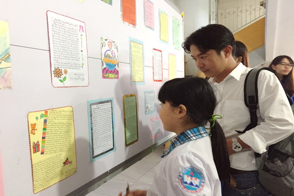 Phụ huynh và học sinh xúc động đọc các bức thư tay gửi thầy cô giáo được trưng bày tại triển lãm. Ảnh: Đ.CÔNG