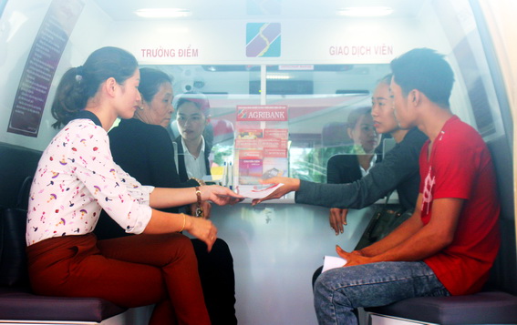 Người dân đến giao dịch tại điểm giao dịch lưu động bằng xe ô tô chuyên dùng tại xã Xuân Hưng, huyện Xuân Lộc.