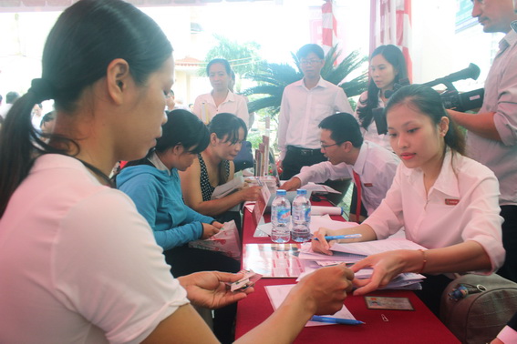 Các giao dịch viên hướng dẫn người dân sử dụng dịch vụ