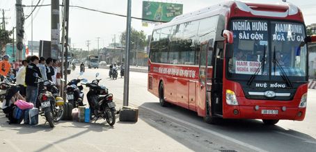 Người dân chờ đón xe khách đi các tỉnh phía Bắc tại khu vực Amata trên quốc lộ 1 (TP.Biên Hòa). (Ảnh chụp ngày 31-12-2017). Ảnh: T.Hải