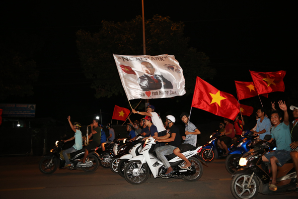 Người hâm mộ diễu hành mang cờ in hình HLV người Hàn Quốc diễu hành trên đường Võ Thị Sáu