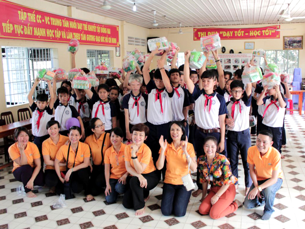 Các nhân viên công ty cổ phần đô thi Amata Biên Hòa chụp hình lưu niệm cùng học sinh của trung tâm