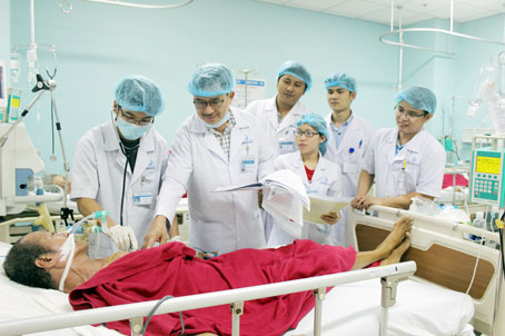 Bác sĩ Hoàng Đại Thắng, Trưởng khoa Hồi sức tích cực - chống độc Bệnh viện đa khoa Đồng Nai (thứ 2 từ trái qua), đang hướng dẫn các bác sĩ trẻ chẩn đoán một ca bệnh nặng. Ảnh: N.Thư