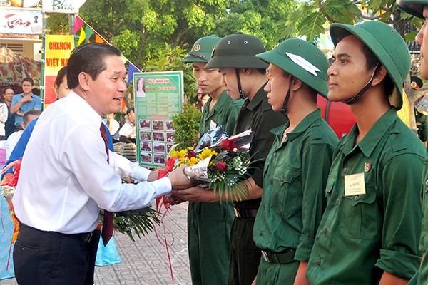 Chủ tịch UBND huyện Trần Quang Tú tặng hoa cho thanh niên trước khi lên đường 