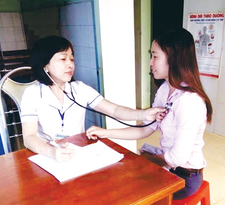 Bà Huỳnh Thị Thủy (trái) thăm, khám bệnh cho người dân.