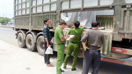 Cơ quan công an khám nghiệm hiện trường và chiếc xe bị cướp 27 tấn bã đậu nành.