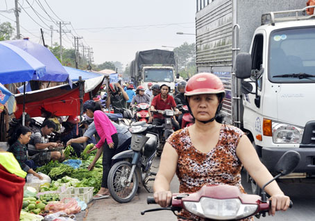 Chợ tạm trên đường Điểu Xiển (thuộc phường Long Bình, TP.Biên Hòa) hàng quán ngay sát đường, người mua đông đúc gây kẹt xe kéo dài như cơm bữa.