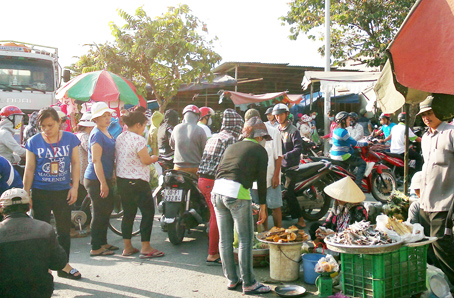Trên đường Nguyễn Thị Tồn (giáp giữa phường Bửu Hòa và xã Hóa An, TP.Biên Hòa), giao thông lộn xộn vì họp chợ. Xe tải lớn đi qua không được vì kẹt giữa dòng người và xe đông đúc.