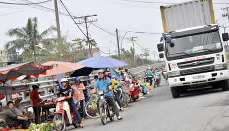 Góc chợ “cóc” hàng rong được lập trên đường vào Khu công nghiệp Hố Nai (thuộc xã Hố Nai 3, huyện Trảng Bom) giữa những xe lớn.