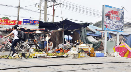 Một gian chợ tạm dựng ngay bên đường sắt đoạn km1687+5 thuộc phường Long Bình, TP.Biên Hòa rất nguy hiểm nếu người dân tụ tập mua bán khi có tàu hỏa chạy qua.