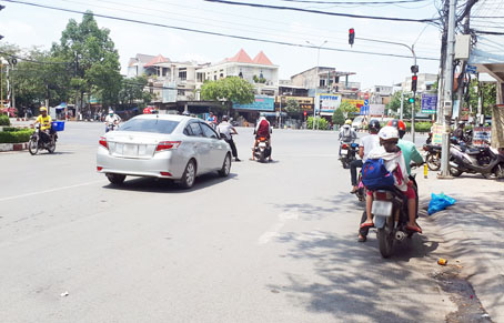 Một số phương tiện dừng xe trong bóng râm, cách khá xa vạch dừng xe tại nút giao giữa đường Phan Đình Phùng và đường Nguyễn Ái Quốc.