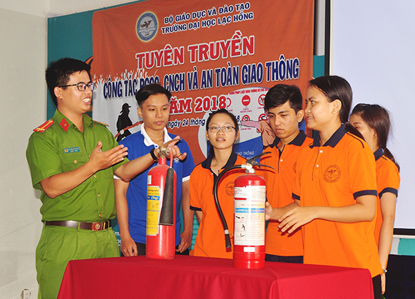 Cảnh sát Phòng cháy và chữa cháy tỉnh hướng dẫn sinh viên cách sử dụng bình chữa cháy xách tay (ảnh: Đăng Tùng)