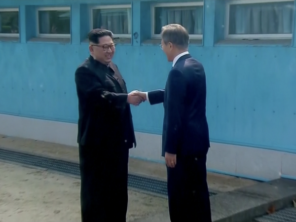Tổng thống Moon Jae-in và lãnh đạo Kim Jong-un đã bắt tay nhau tại đường ranh giới phân định hai miền. (Nguồn: CNN)