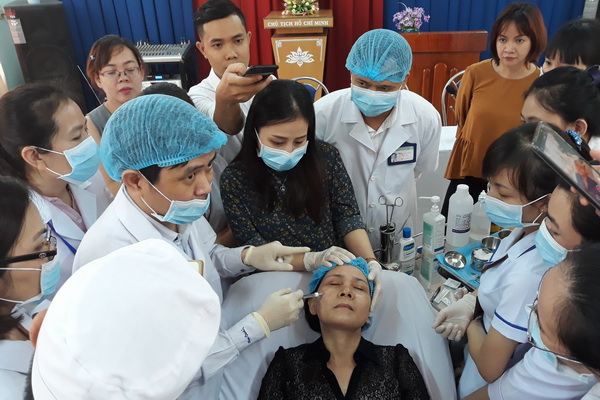 PGS.TS Văn Thế Trung đang hướng dẫn các bác sĩ, kỹ thuật viên của Bệnh viện da liễu Đồng Nai phương pháp tiêm chất làm đầy filler trên mặt một bệnh nhân.